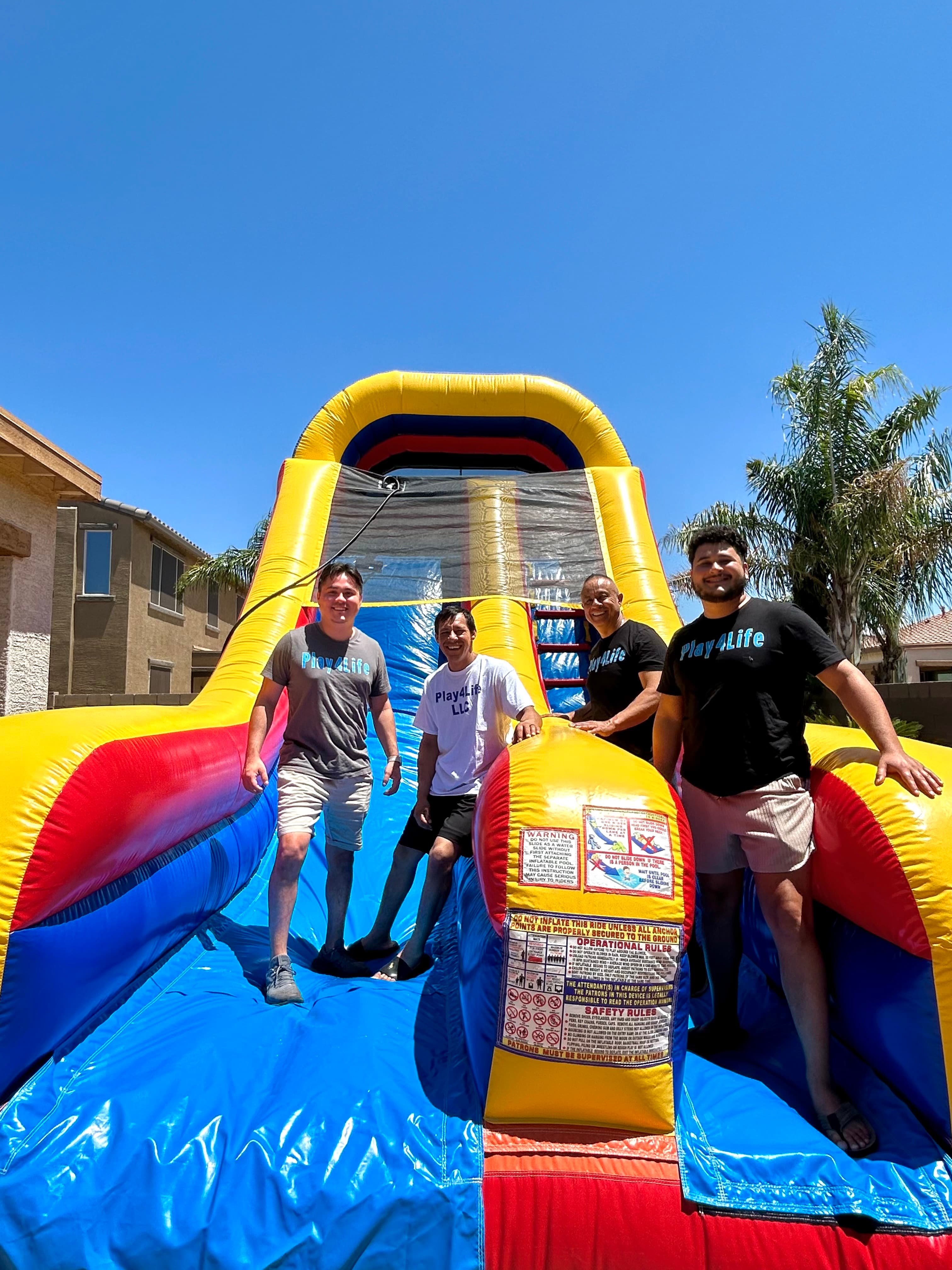 The Play4Life family team with a colorful inflatable slide